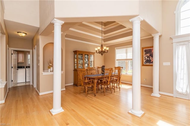 dining room featuring crown molding, light wood finished floors, baseboards, and washer and dryer