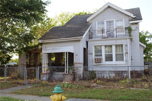 view of front facade featuring cooling unit, a gate, fence private yard, and a balcony
