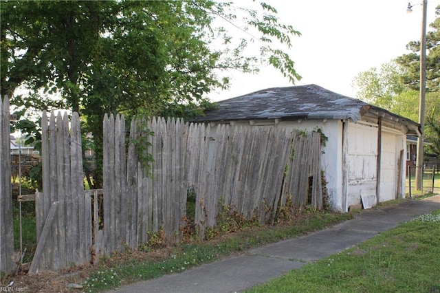 view of outbuilding featuring fence and an outdoor structure