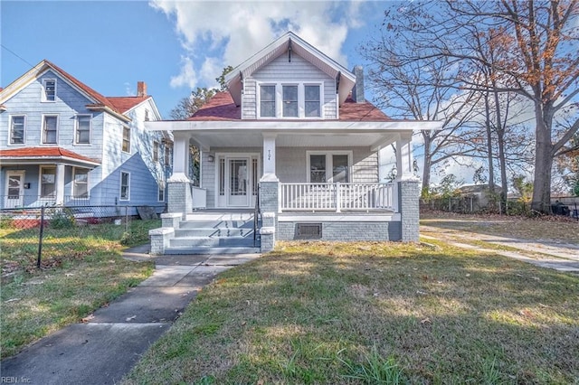 bungalow-style house with fence, a porch, and a front lawn