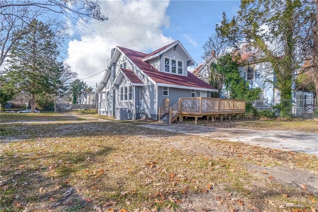 rear view of house with central air condition unit, a wooden deck, and fence