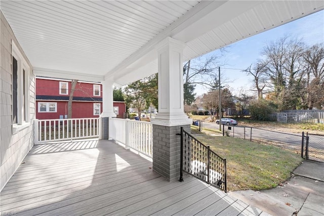 deck featuring fence and covered porch