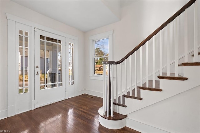 foyer entrance with baseboards, french doors, stairs, and wood finished floors