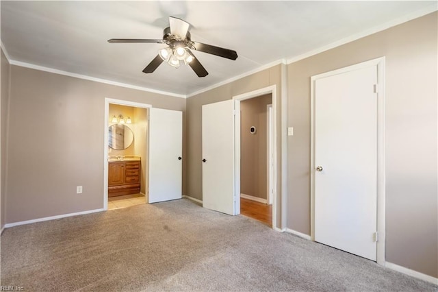 unfurnished bedroom with crown molding, baseboards, carpet flooring, and connected bathroom