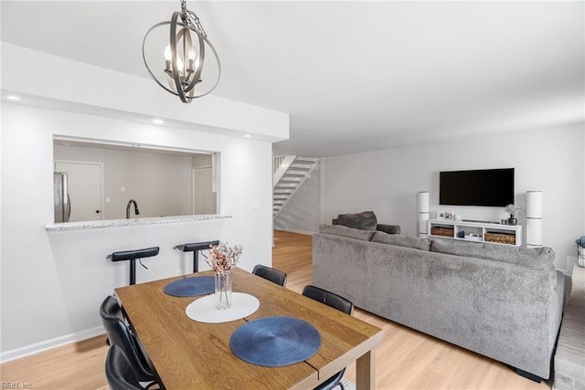 dining space featuring stairs, indoor wet bar, recessed lighting, and light wood-type flooring
