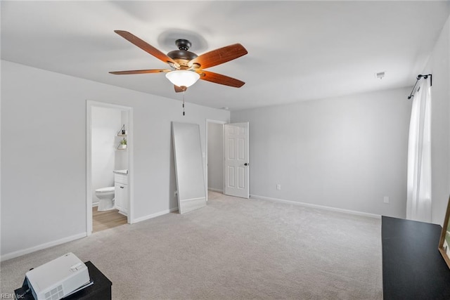 unfurnished bedroom with baseboards, light colored carpet, ceiling fan, and ensuite bath