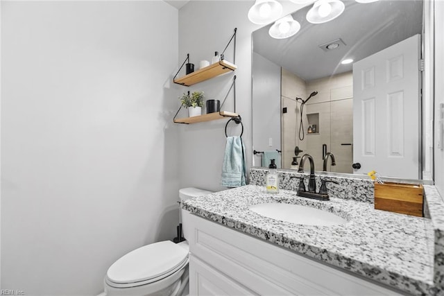 bathroom featuring toilet, a shower stall, and vanity