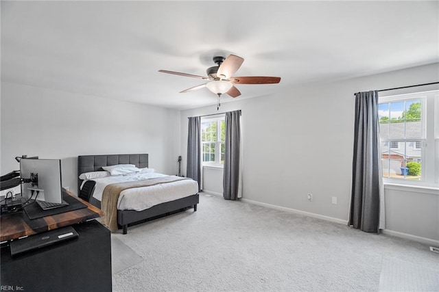 bedroom with baseboards, ceiling fan, visible vents, and light carpet