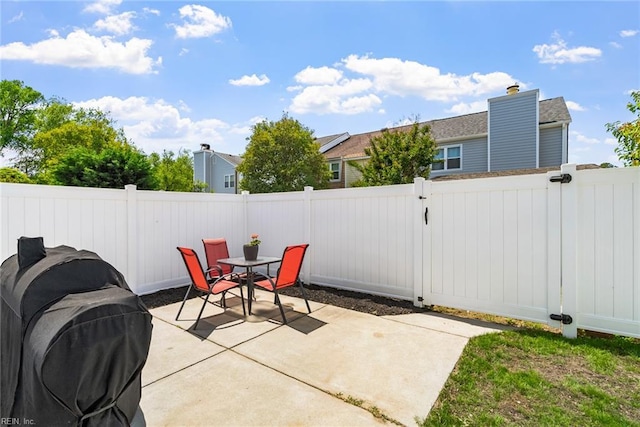 view of patio featuring grilling area, outdoor dining area, and a fenced backyard