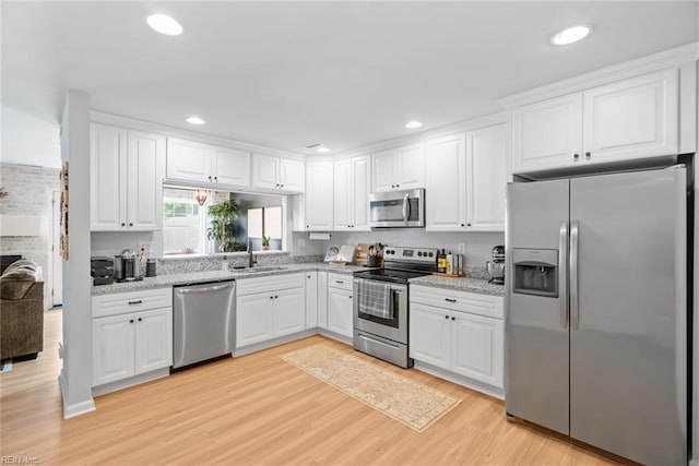 kitchen featuring stainless steel appliances, recessed lighting, white cabinetry, and light wood finished floors