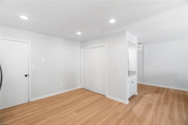 unfurnished bedroom featuring light wood-style floors, recessed lighting, baseboards, and a closet