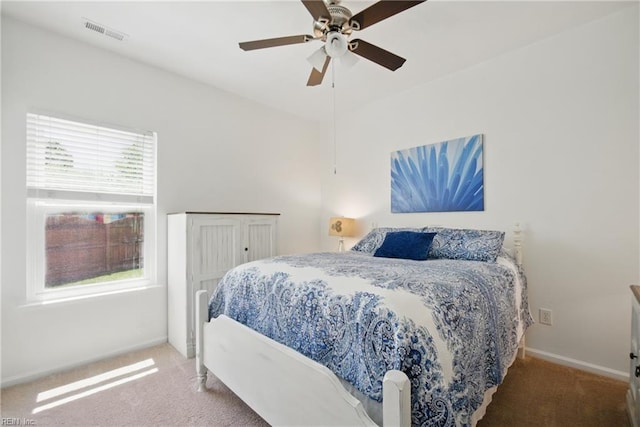 carpeted bedroom with a ceiling fan, baseboards, and visible vents