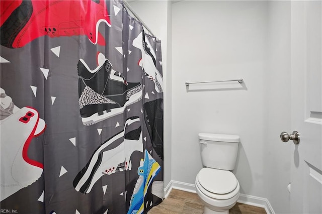 full bathroom with baseboards, a shower with curtain, toilet, and wood finished floors