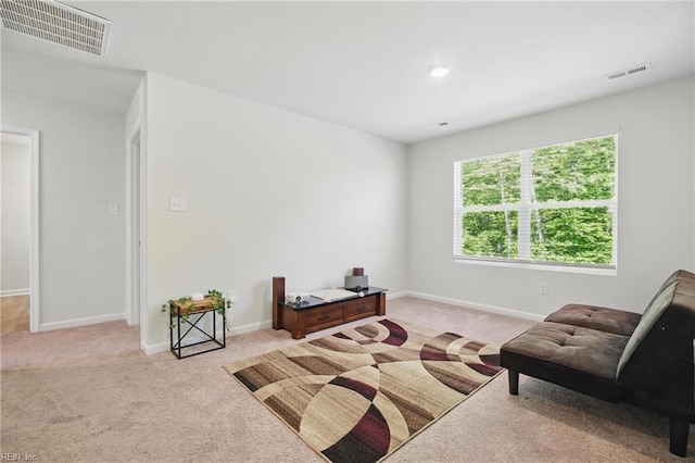 living area featuring visible vents, carpet flooring, and baseboards