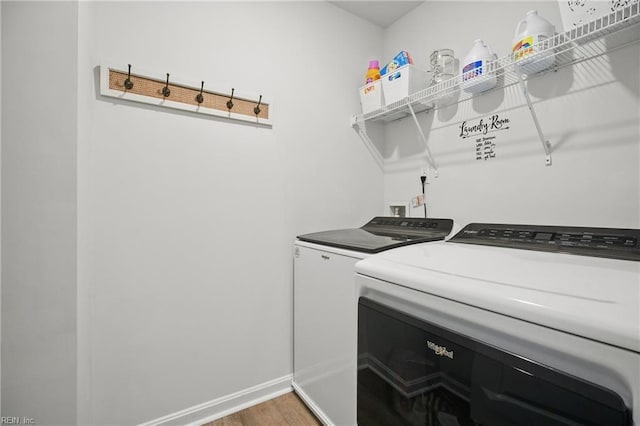 laundry room featuring laundry area, light wood-style floors, baseboards, and separate washer and dryer