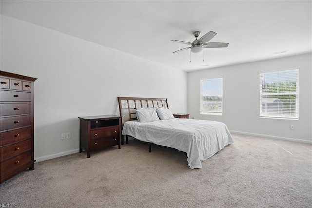 bedroom with baseboards, ceiling fan, and light colored carpet