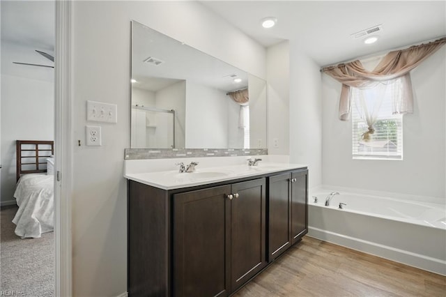 ensuite bathroom with double vanity, visible vents, and a sink