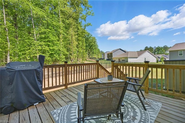 wooden terrace featuring outdoor dining area, a residential view, and area for grilling