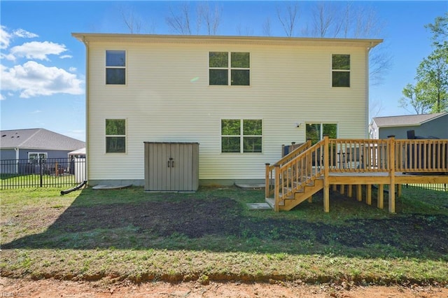 back of house with stairs, a lawn, fence, and a wooden deck
