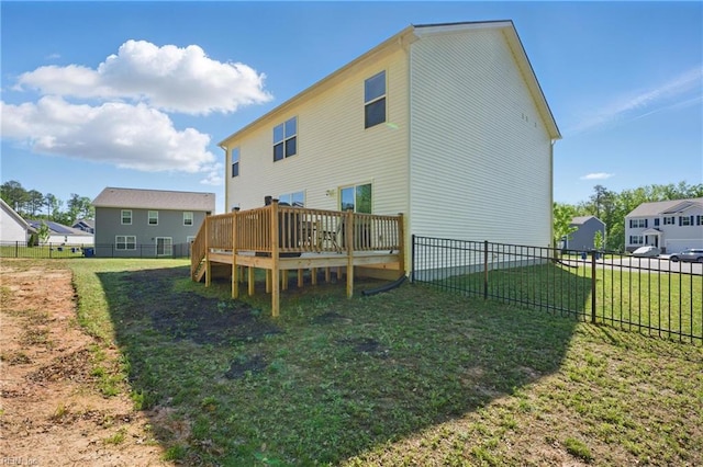 rear view of property featuring a fenced backyard, a yard, and a deck