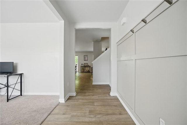 hallway with light wood-style floors and baseboards