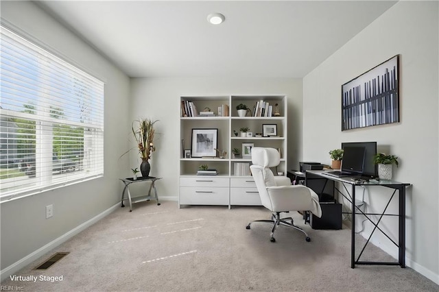 home office featuring baseboards, visible vents, and light carpet