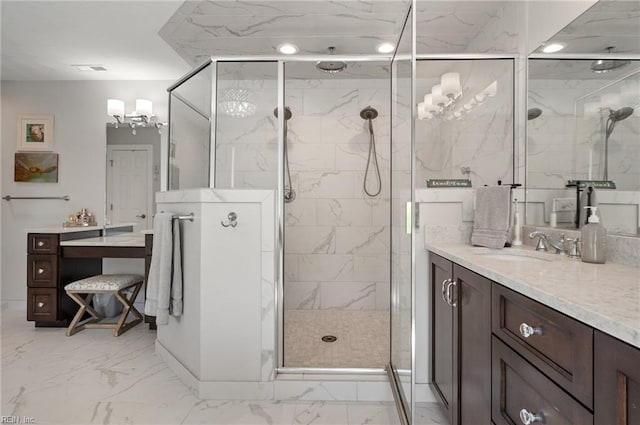 full bath featuring vanity, marble finish floor, a stall shower, and a notable chandelier