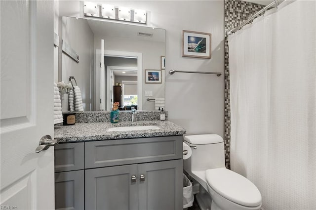 bathroom featuring toilet, a shower with curtain, visible vents, and vanity