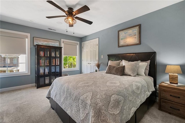 bedroom with a ceiling fan, visible vents, baseboards, a closet, and carpet