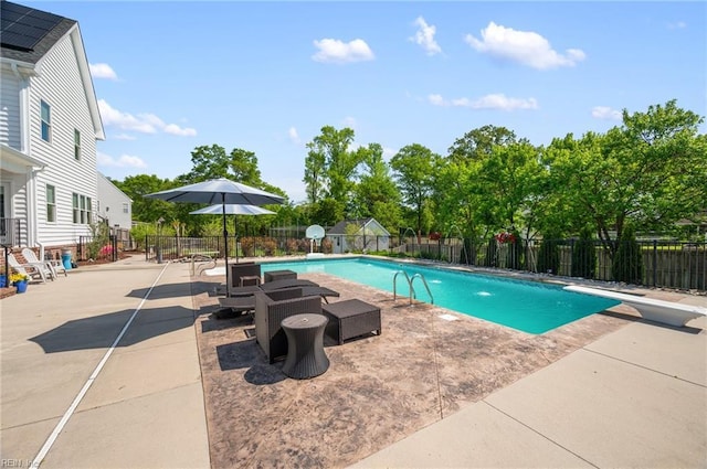 view of swimming pool with a patio, a fenced backyard, a diving board, and a fenced in pool