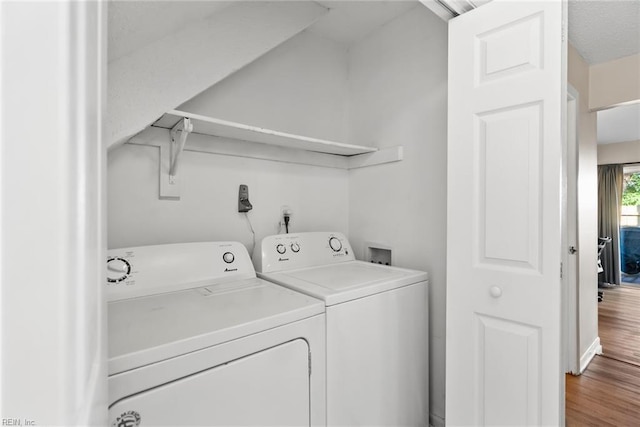 laundry room featuring laundry area, wood finished floors, and washing machine and clothes dryer