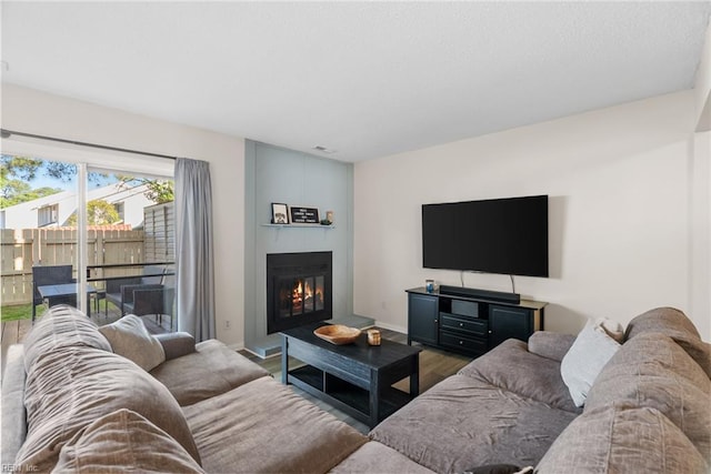 living room featuring baseboards, a fireplace, and wood finished floors