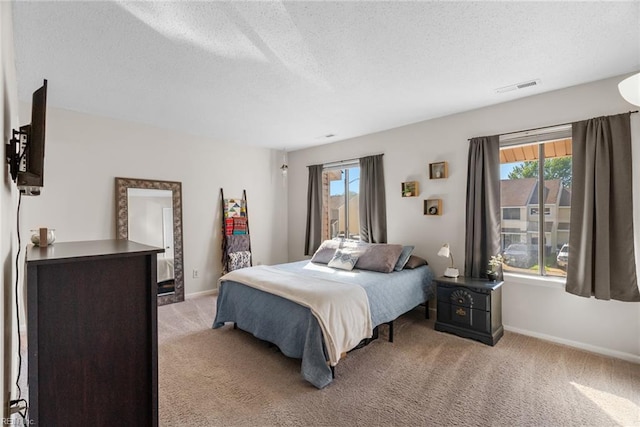 bedroom with light colored carpet, baseboards, visible vents, and multiple windows