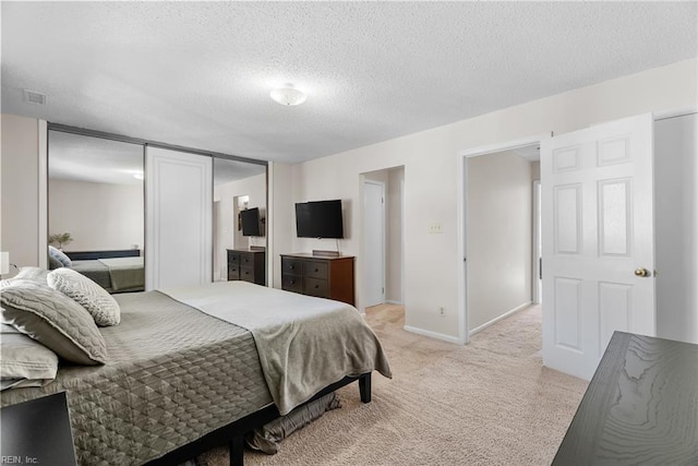 bedroom with baseboards, visible vents, a textured ceiling, and light colored carpet