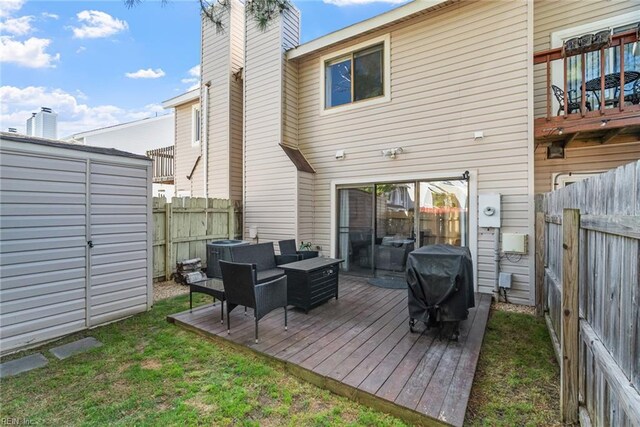 rear view of house with a deck, a fenced backyard, central AC unit, a chimney, and a yard