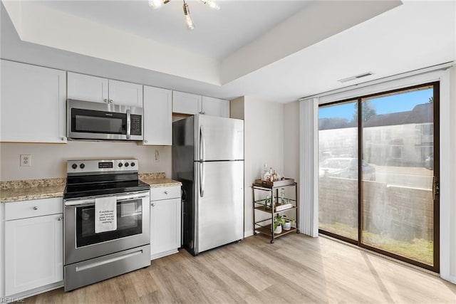 kitchen featuring visible vents, light wood finished floors, appliances with stainless steel finishes, and white cabinetry