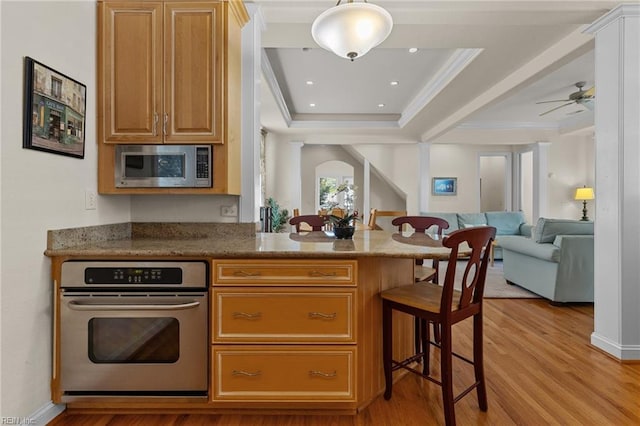 8506 Atlantic Ave Unit B, Virginia Beach, VA 23451 - kitchen featuring a breakfast bar, open floor plan, a raised ceiling, light wood finished floors, and appliances with stainless steel finishes