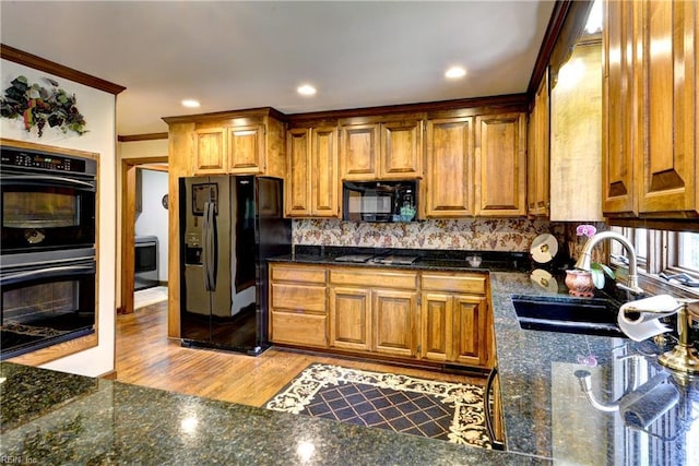 kitchen featuring decorative backsplash, brown cabinets, a sink, black appliances, and ornamental molding