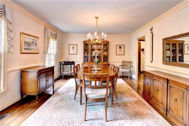 dining space featuring visible vents, ornamental molding, a chandelier, and dark wood-style floors