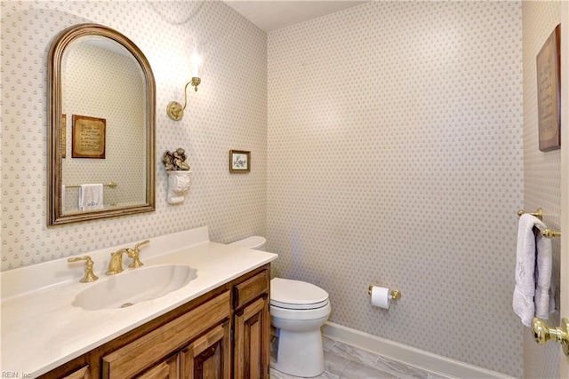bathroom featuring vanity, baseboards, and toilet