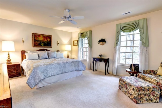 carpeted bedroom with visible vents, a ceiling fan, and baseboards