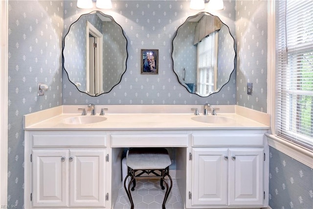 bathroom featuring double vanity, a sink, and wallpapered walls