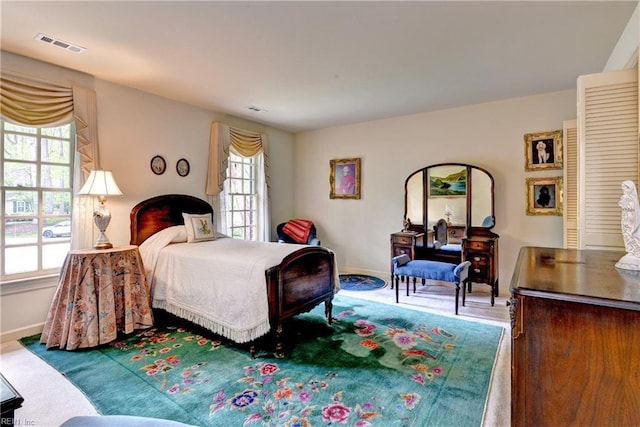 bedroom with visible vents, baseboards, and multiple windows