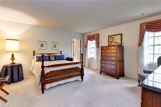 bedroom with baseboards, multiple windows, light carpet, and visible vents