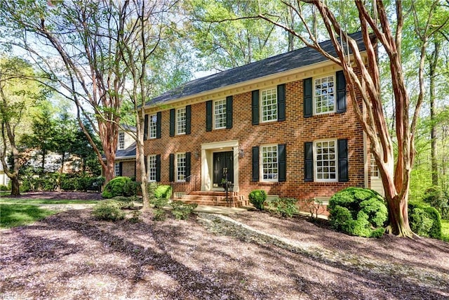 colonial inspired home with brick siding