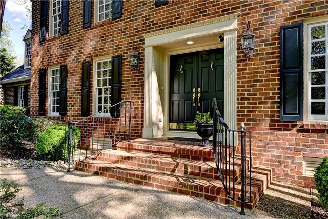 doorway to property featuring brick siding