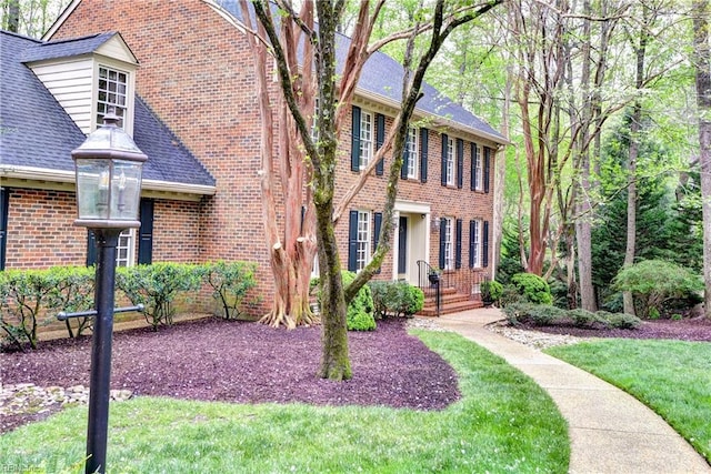 view of front of house featuring a front lawn and brick siding