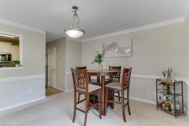 dining area featuring baseboards, ornamental molding, a textured ceiling, and light carpet