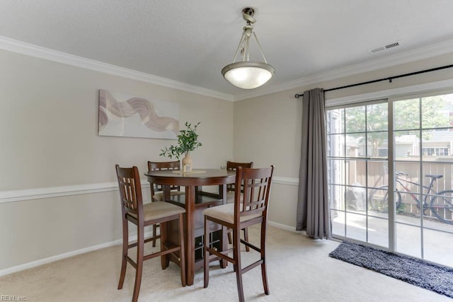 dining space with visible vents, baseboards, crown molding, and light carpet