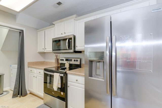 kitchen featuring light countertops, appliances with stainless steel finishes, white cabinets, and visible vents